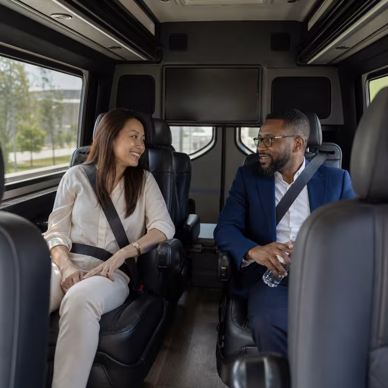 Group boarding a white charter bus for Corporate Transportation transportation in Indianapolis