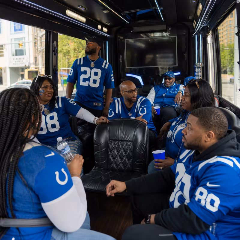 Group boarding a white charter bus for Sporting Event Transportation transportation in Indianapolis